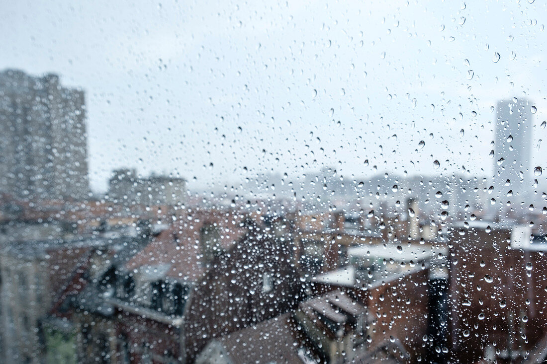 City rooftops through a rain-spattered window