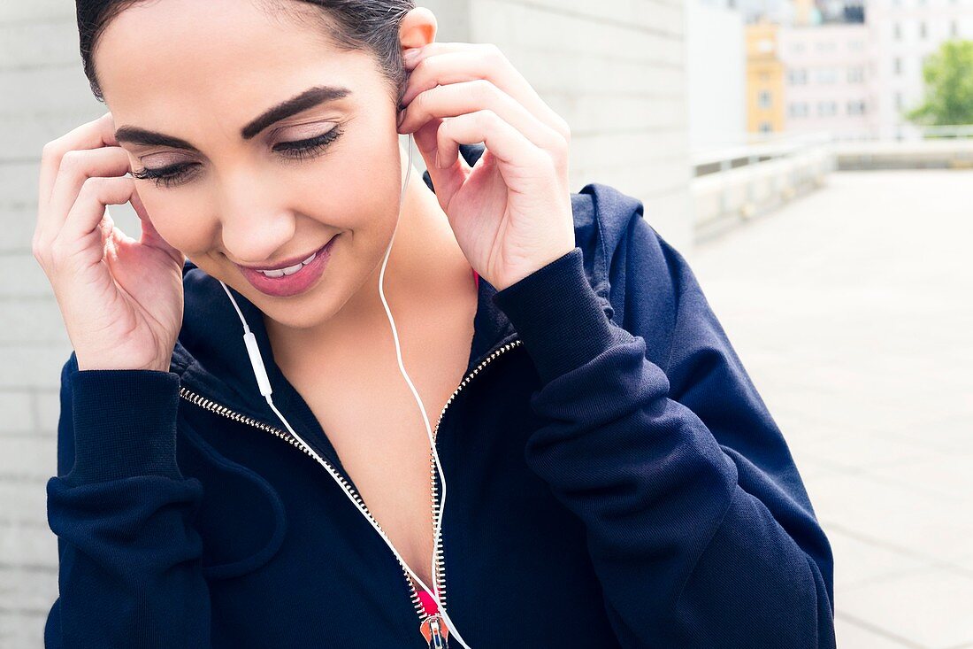 Woman wearing earphones, smiling