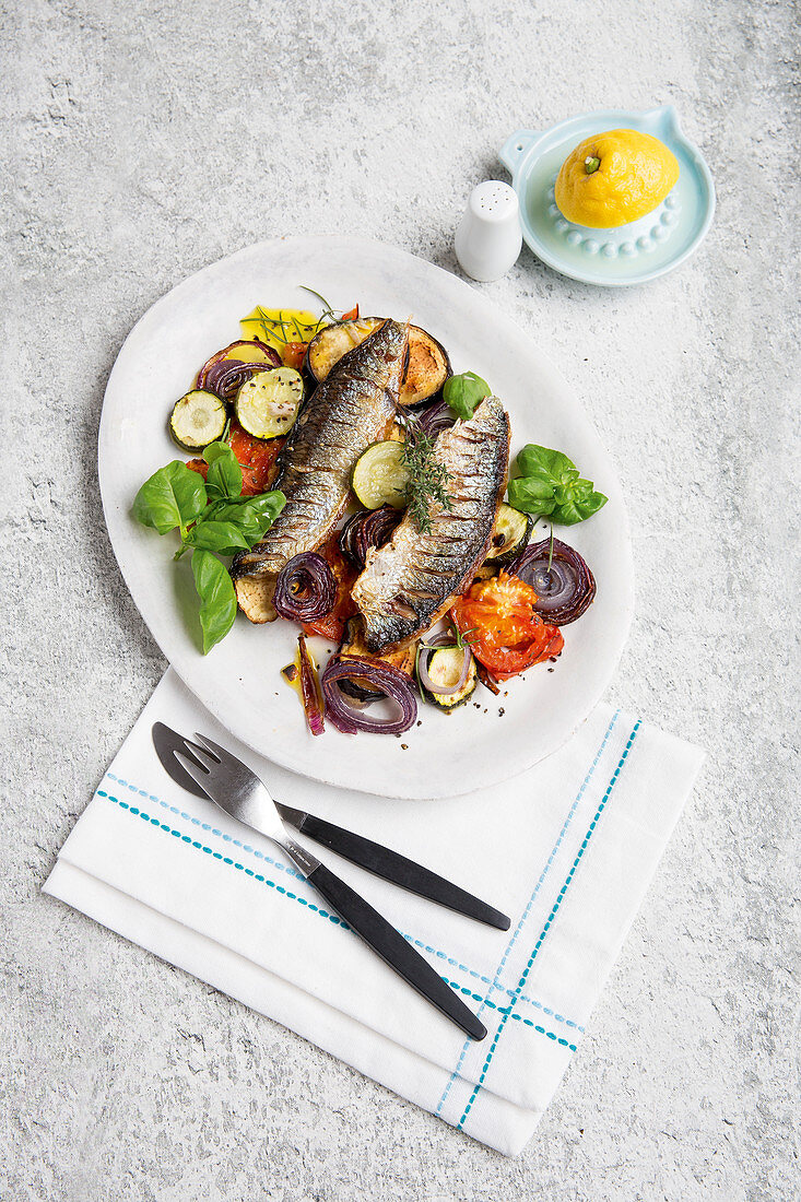 Fried herring on a bed of Mediterranean vegetables