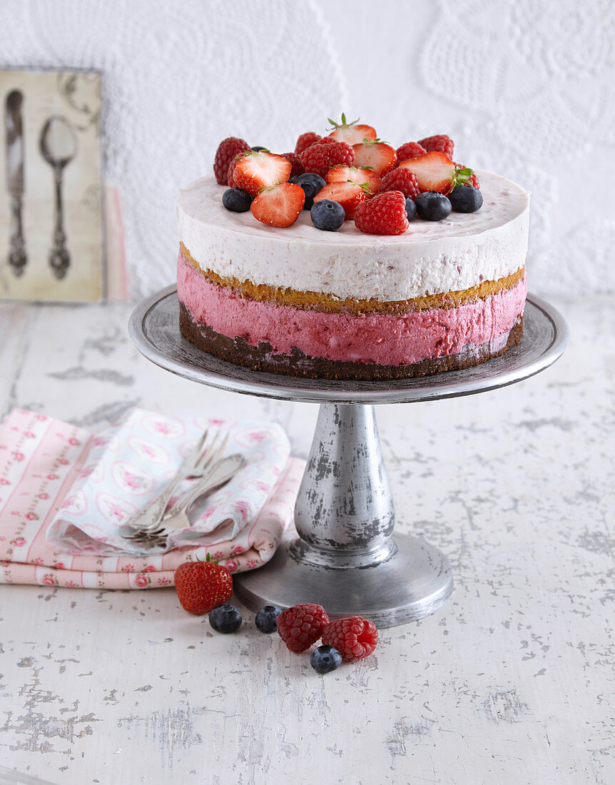 A striped layer cake topped with a trio of fruits