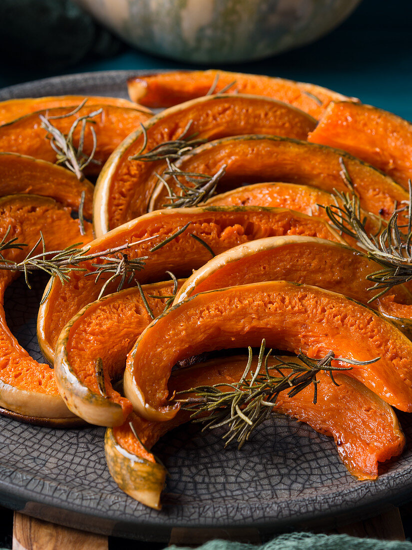 Pumpkin slices baked with rosemary served on gray dish