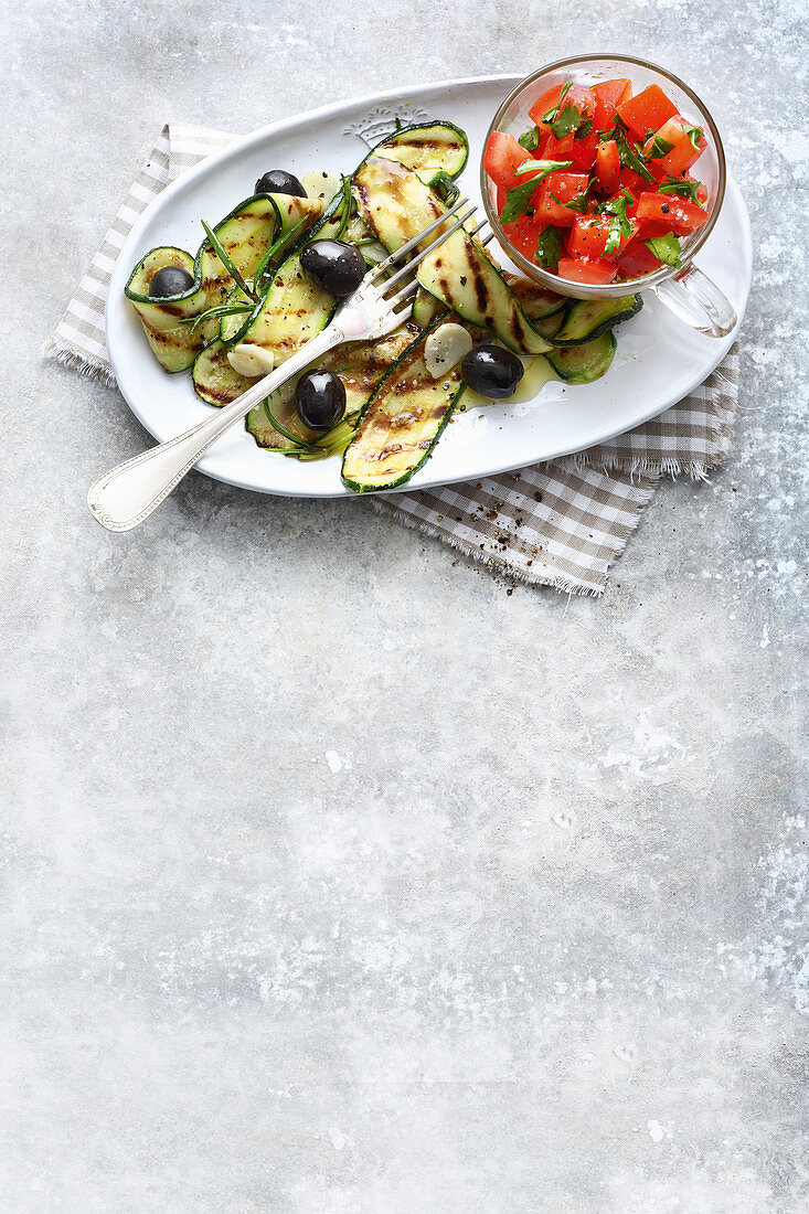Grilled courgette with olives and tomato salad