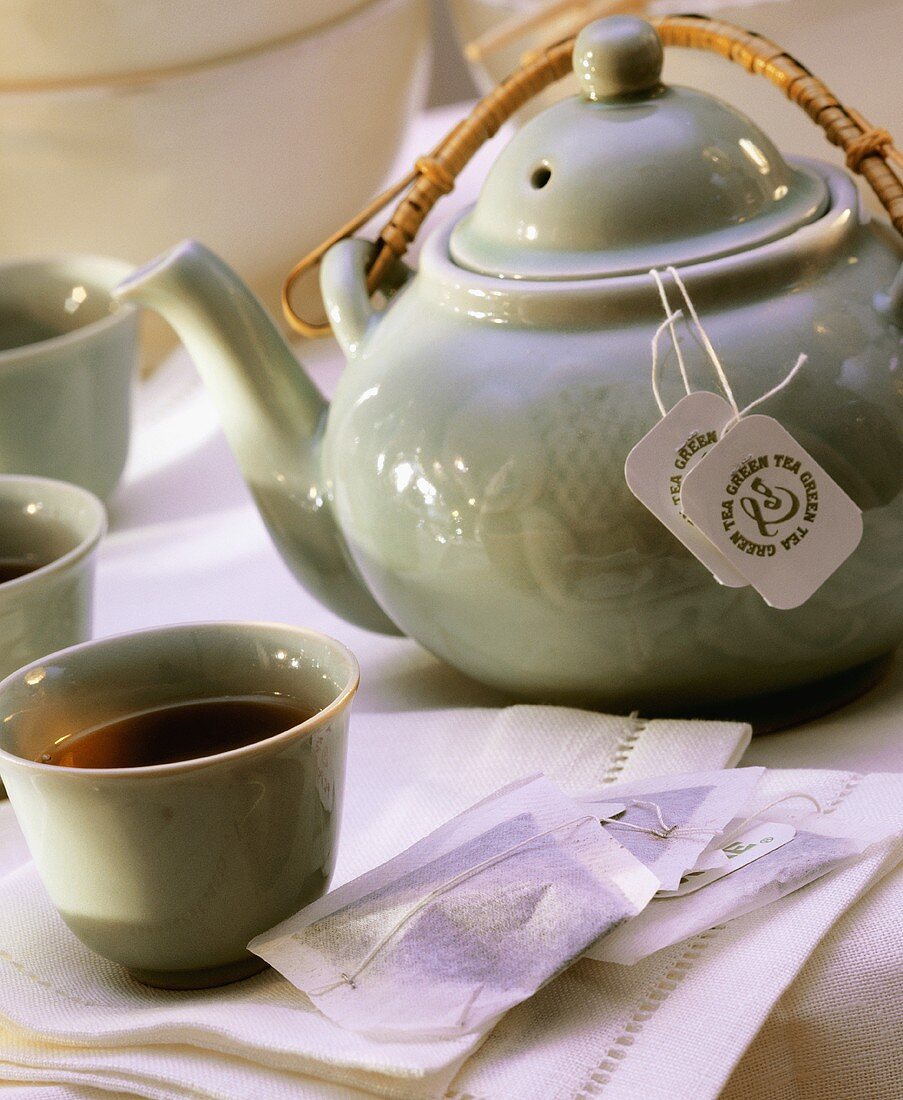 Grüner Tee in Teeschale & -kanne mit Teebeuteln
