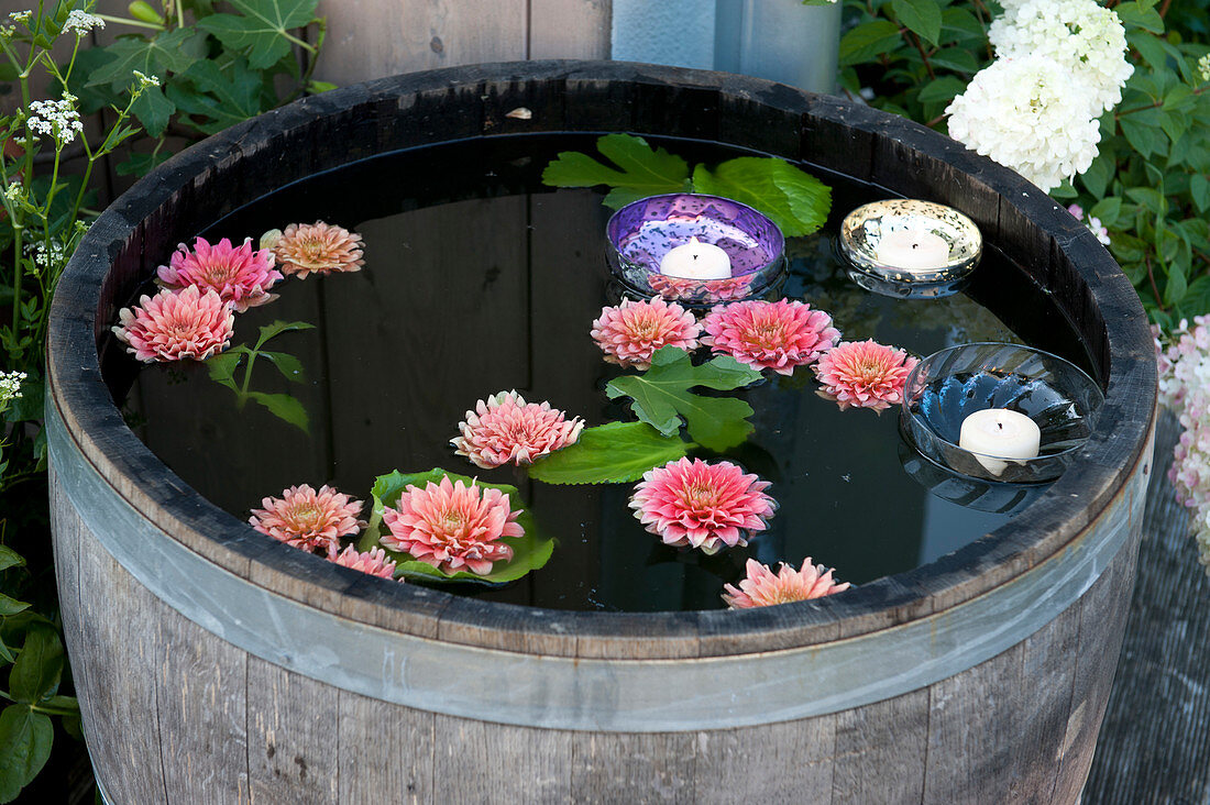 Floating dahlias flowers and glass bowls with candles