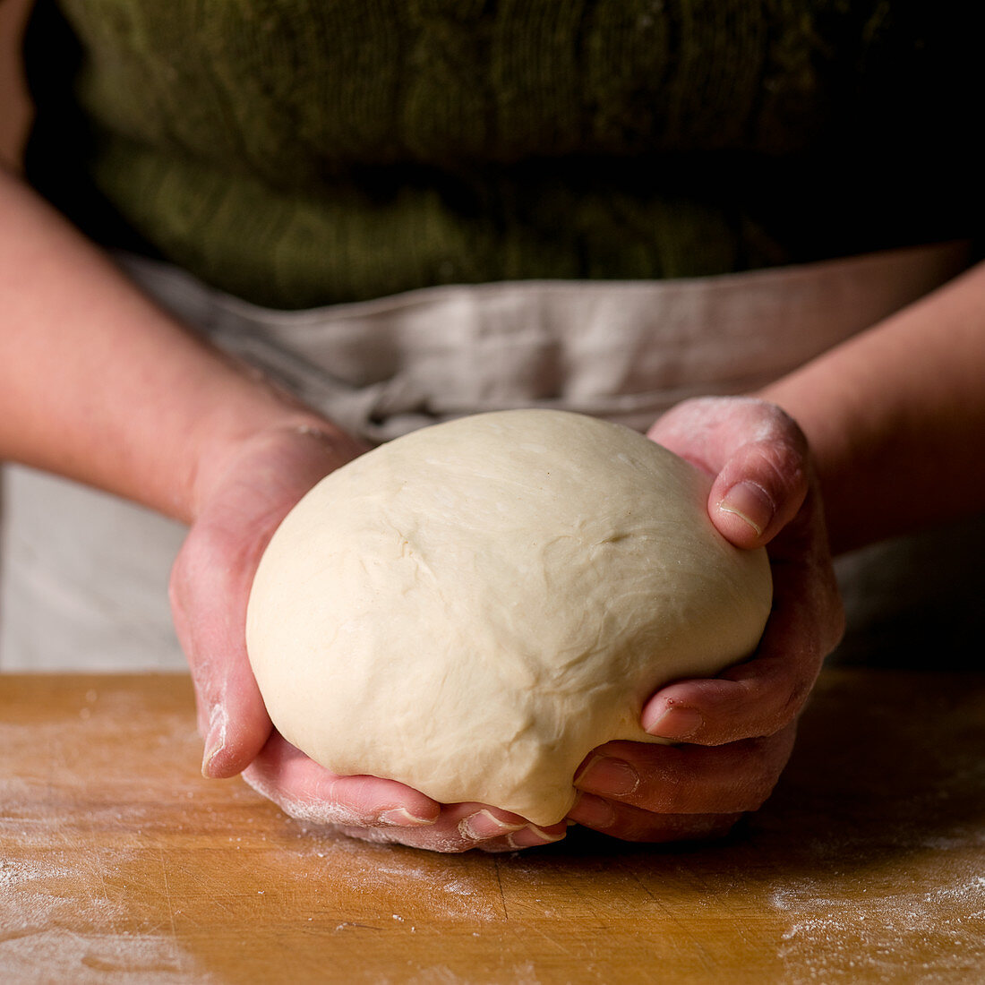 Person holding a ball of dough