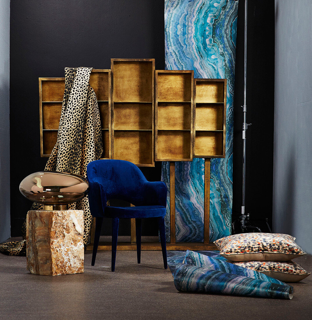 Luxurious wallpaper and fabrics, floor cushions, blue chair and shiny metallic lamp