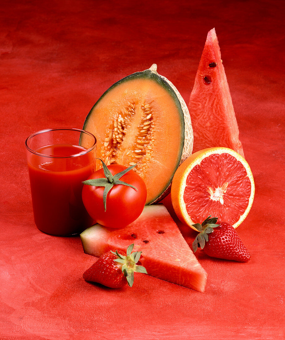 Red fruits, a tomato and a glass of tomato juice