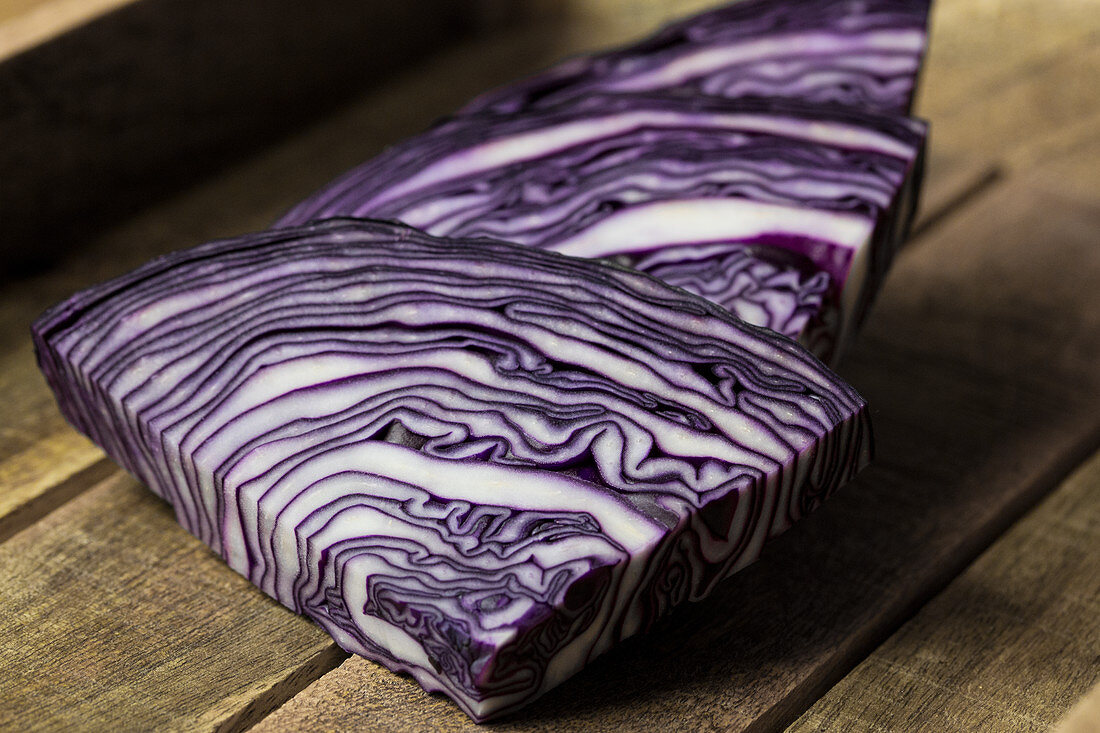 Red cabbage slices on a wooden background