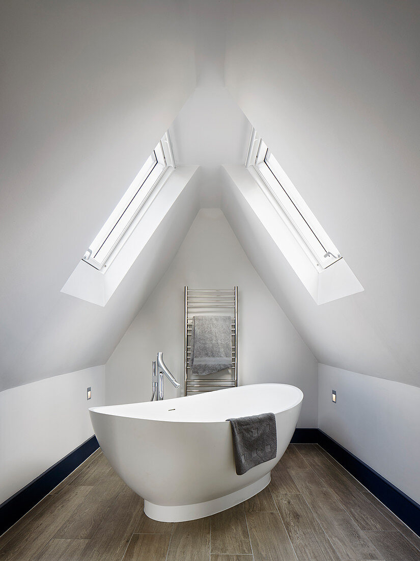 Free-standing oval bathtub in bathroom in gable room