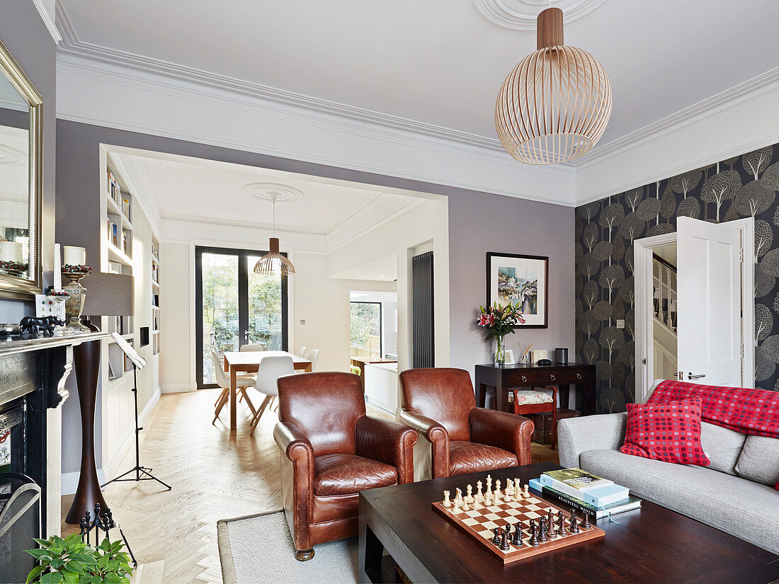 Leather armchair in living room in front of open doorway leading into dining room