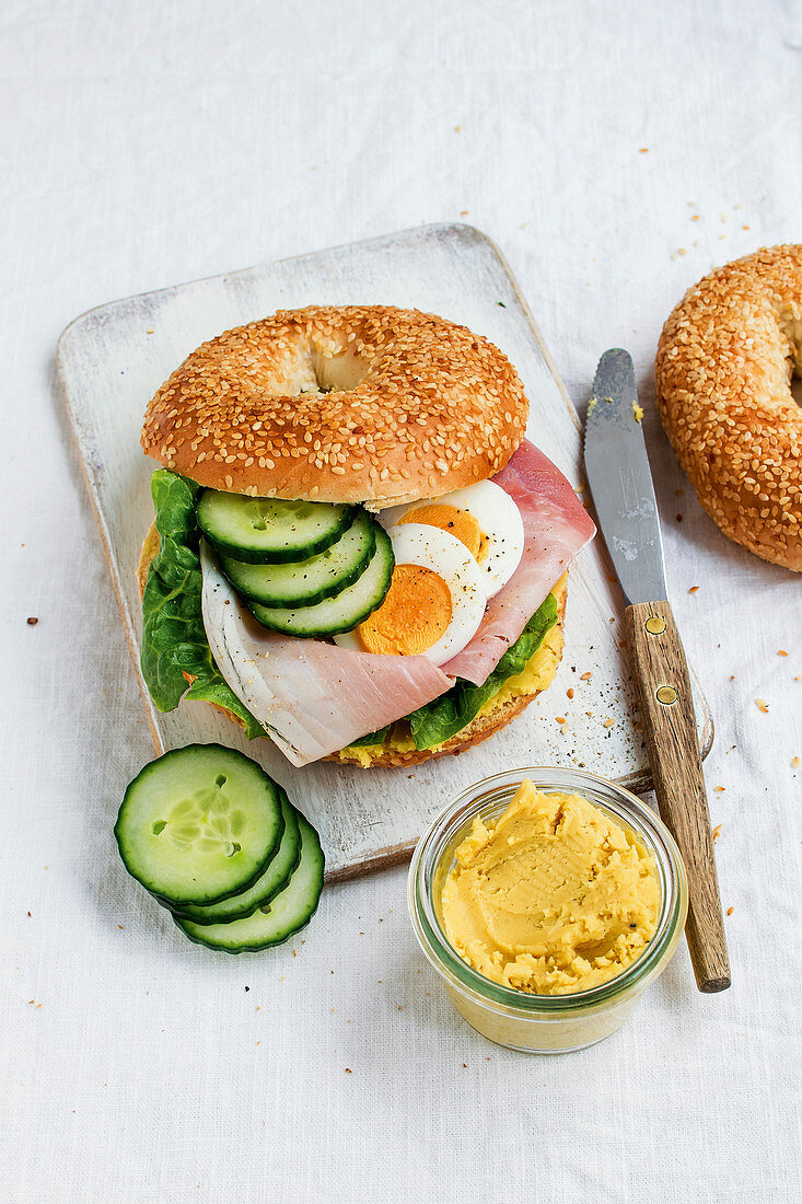 A ham and egg bagel with cucumber
