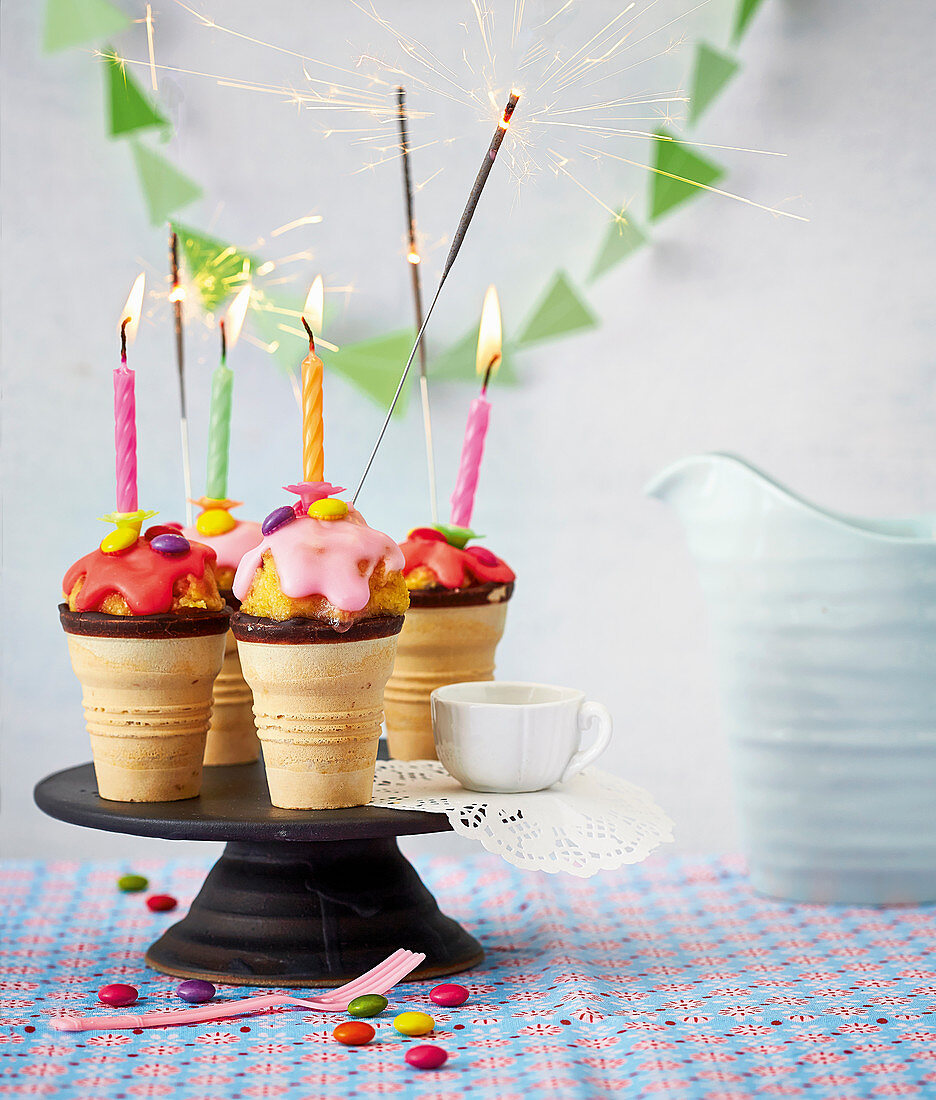 Cakepop-Eisbecher mit brennenden Wunderkerzen