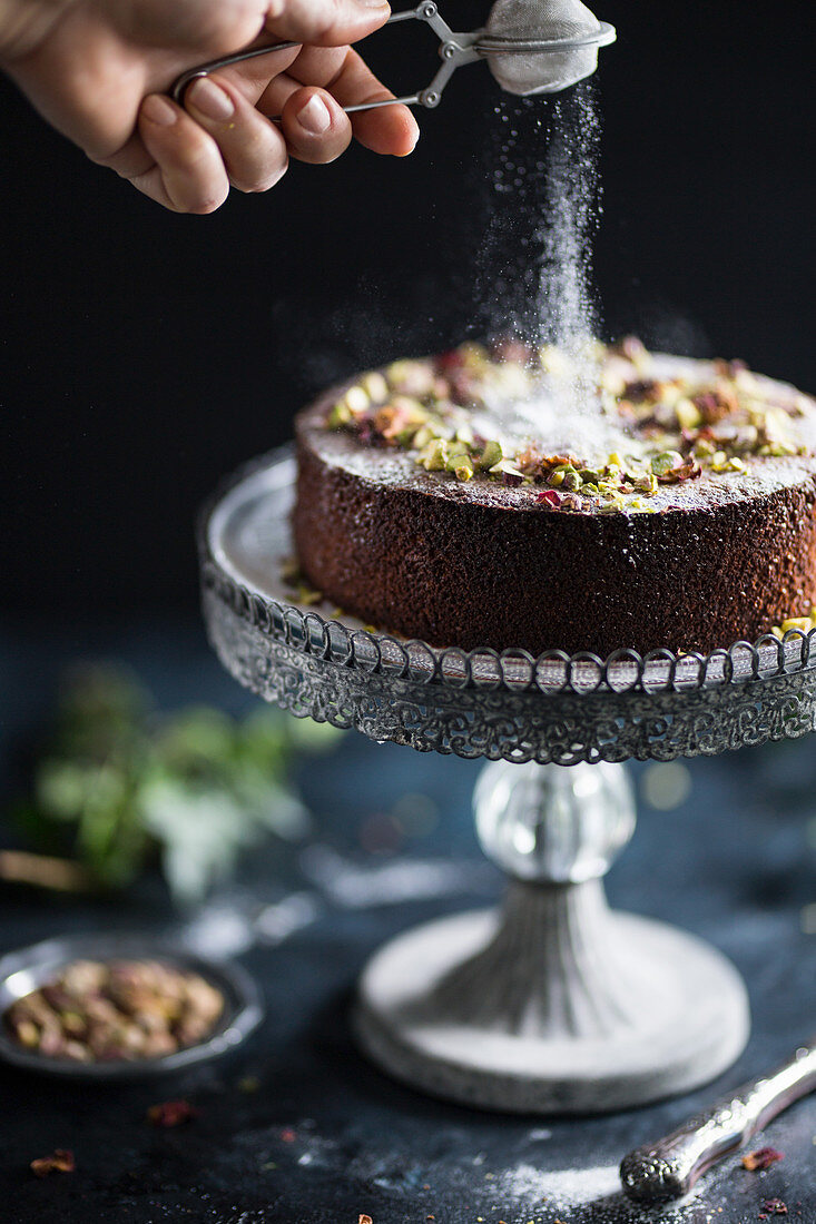 Orangen-Pistazien-Kuchen mit Puderzucker bestauben