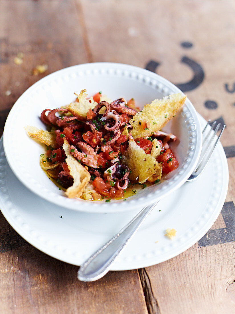 Warm octopus with tomatoes and grilled bread