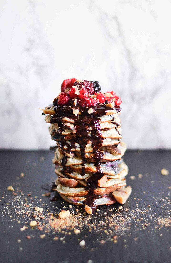 Gestapelte Pancakes mit Beeren und Schokoladensauce