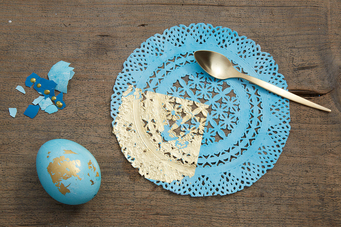 Easter egg and doily decorated in blue and gold