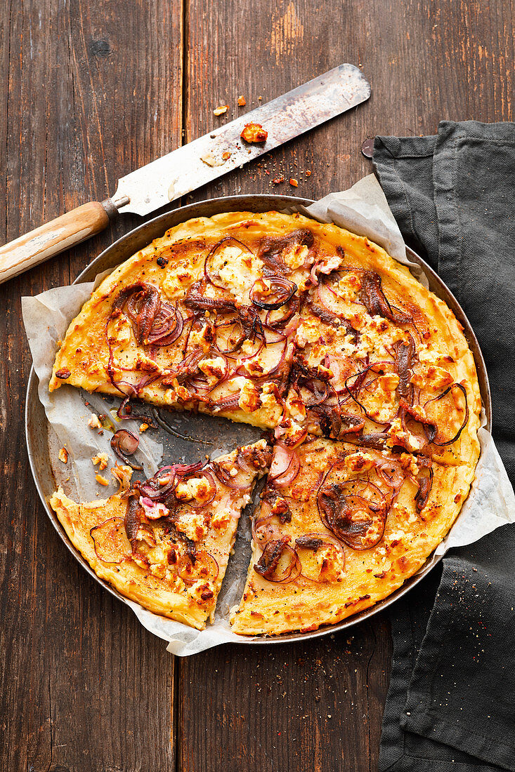 Potato pizza with anchovies and red onions