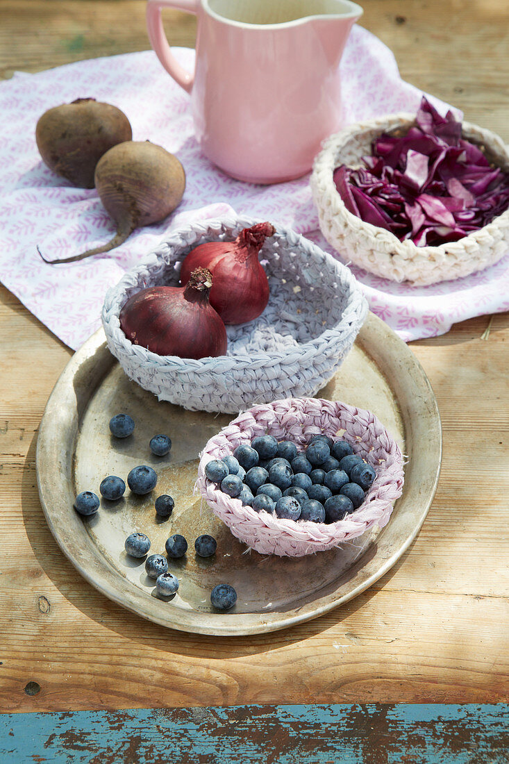 Blueberries and red onions in hand-crocheted basket made from dyed fabric strips