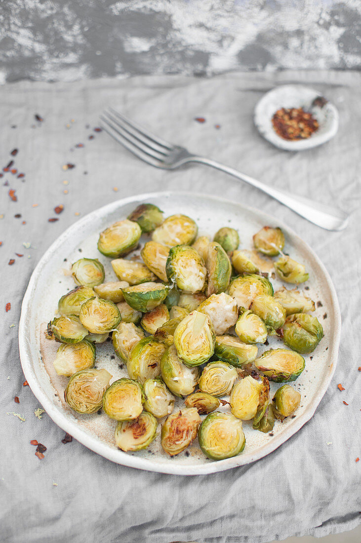 Oven baked brussel sprout with grated parmesan cheese, lemon zest and chili flakes