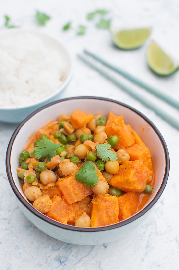 Thai vegan curry with sweet potato, green peas, chickpeas, coconut milk and red curry paste