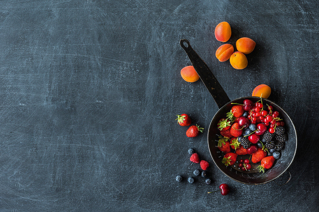 Frische Beeren in einer Pfanne und Aprikosen