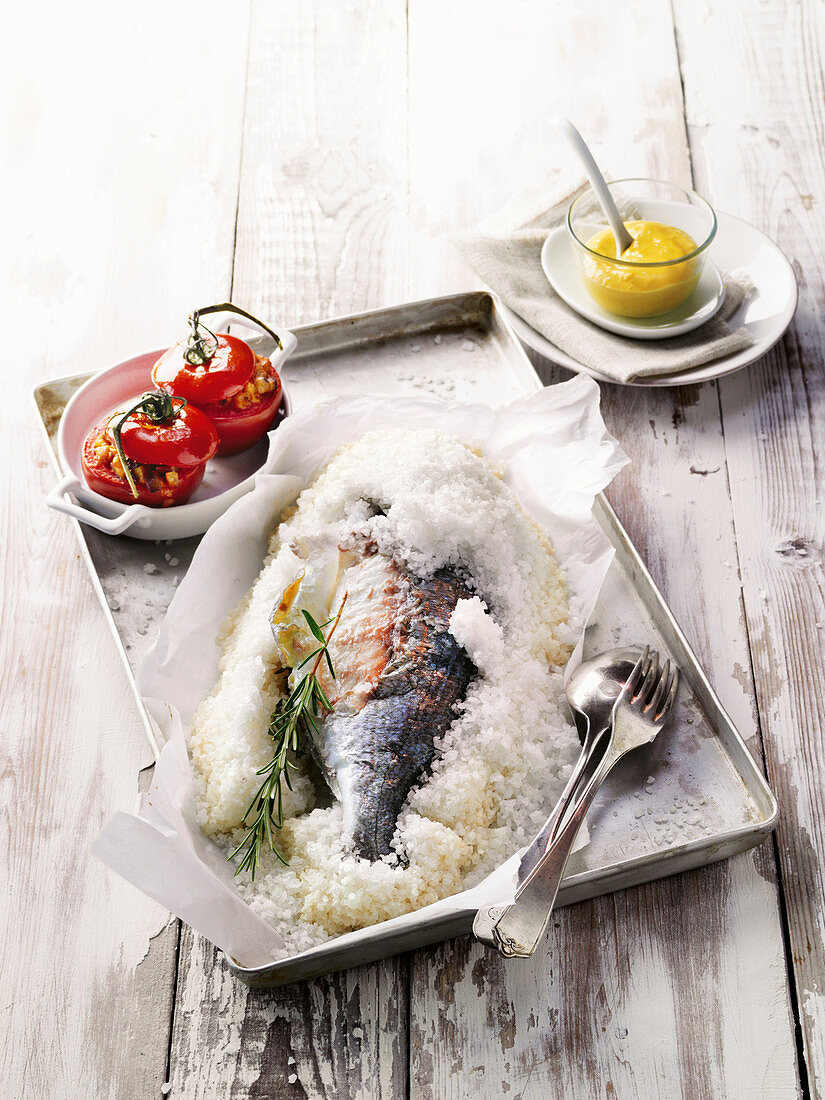 Gilthead seabream in a salt crust with stuffed, grilled tomatoes and aioli