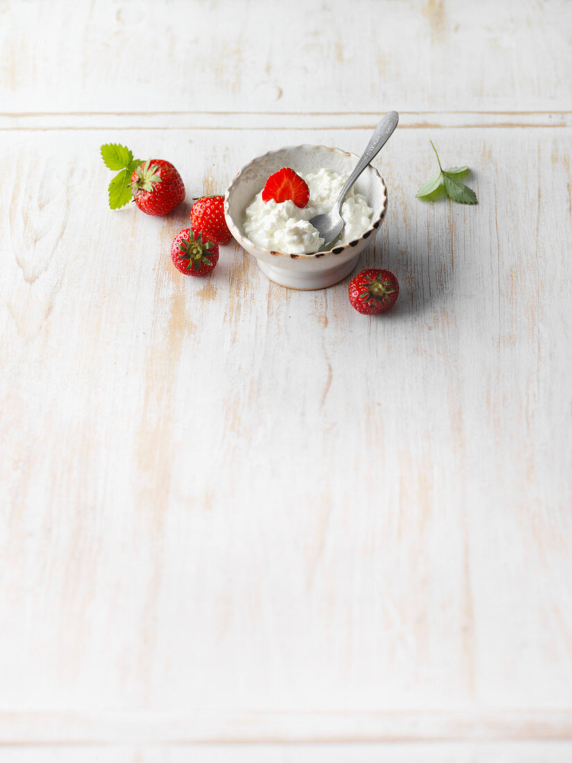 Frische Erdbeeren und körniger Frischkäse