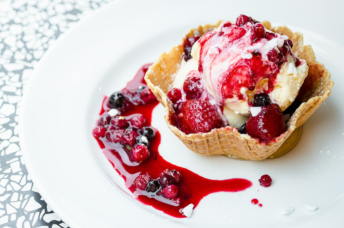 Vanilla ice cream with berry sauce in a wafer bowl