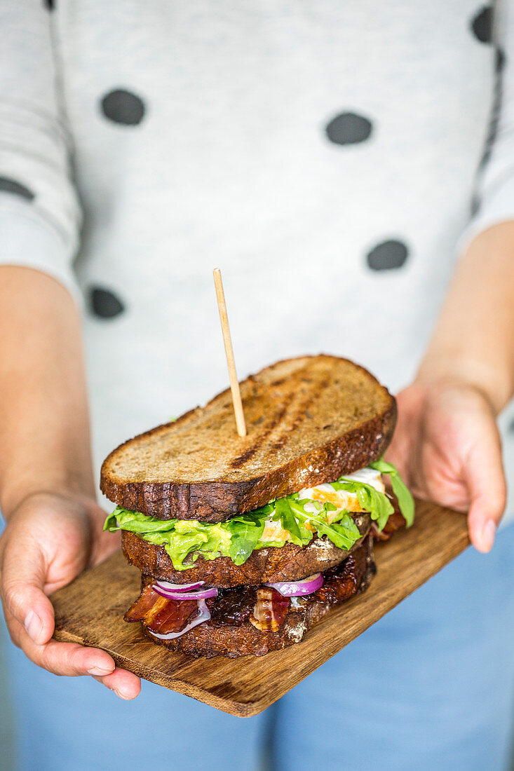 A grilled sandwich with vegetables, egg and bacon