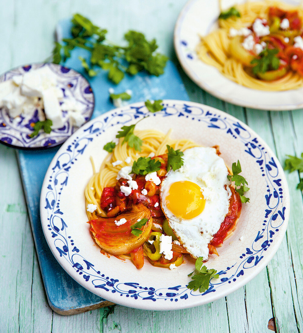 Turkish vegetable pasta with feta cheese and fried eggs