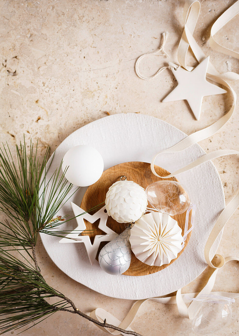 Weihnachtsschmuck auf weißem Teller mit Holzschale