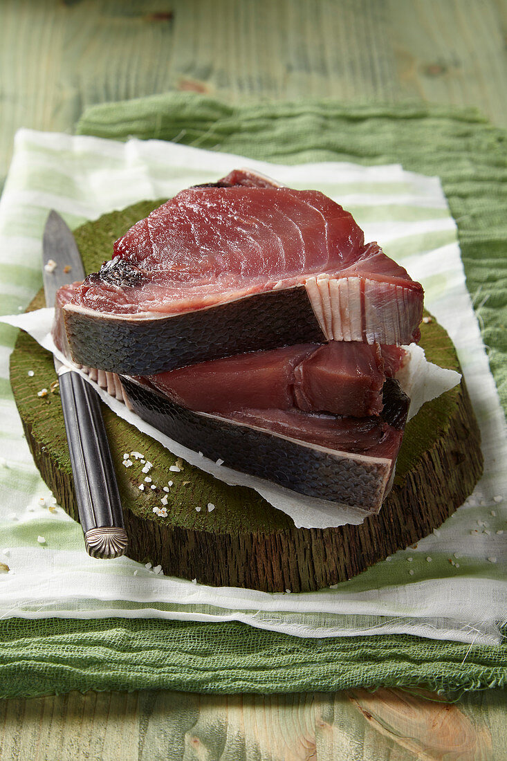 Three slices of raw tuna on a chopping board