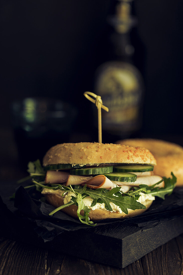 Bagel-Sandwich mit geräucherter Putenbrust, Rucola und Gurken