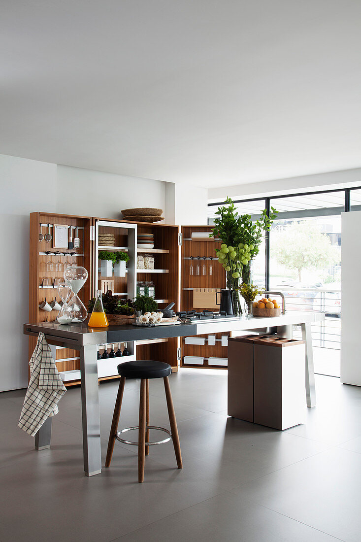 Stainless steel island counter and trunk-style folding cabinet in kitchen