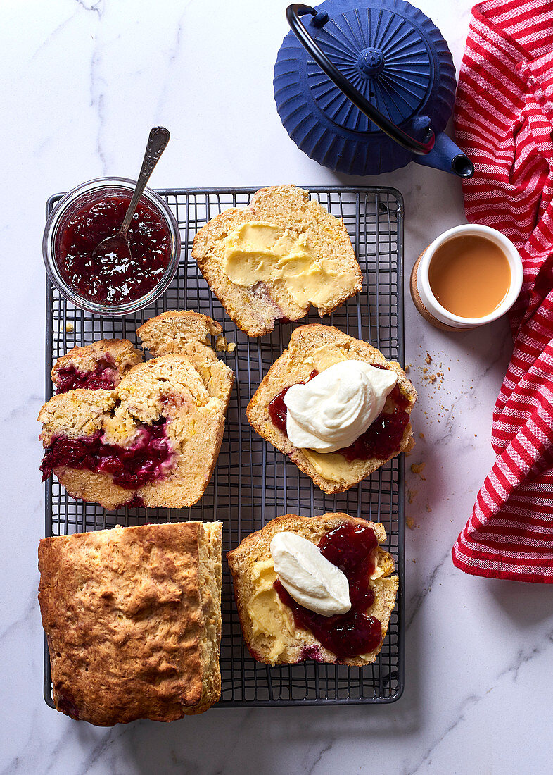 Cranberry scone bread with butter, raspberry jam and whipped cream