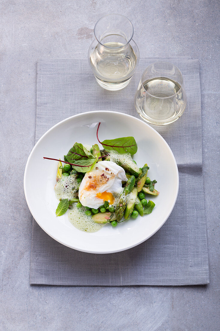 A poached egg with green vegetables