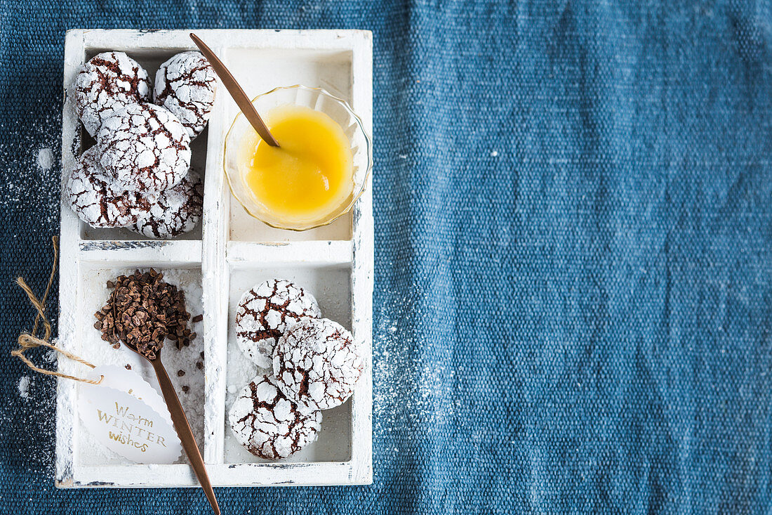 Schokoladen-Apfelmus-Crinkles mit Zutaten in Holzkasten (Aufsicht)