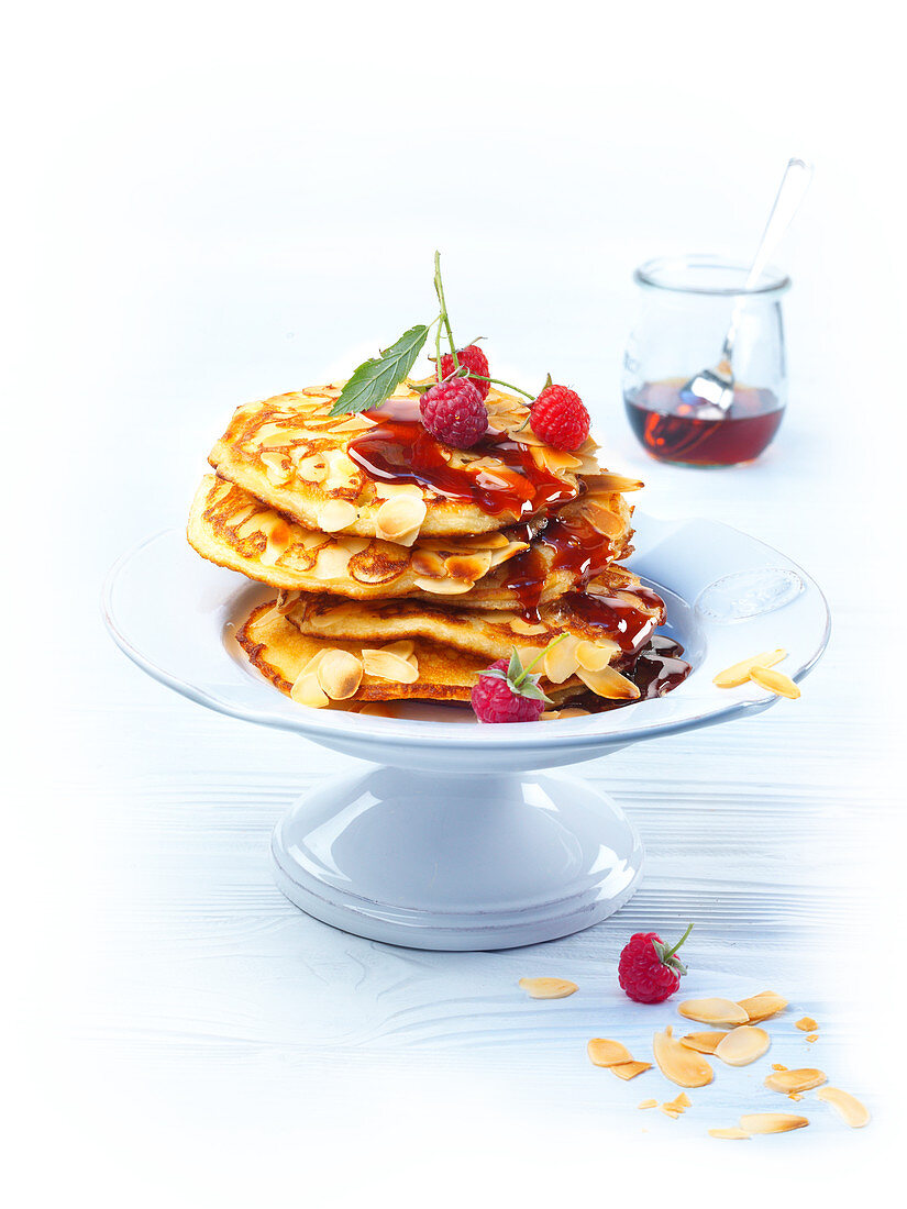 Yeast pancakes with raspberry sauce and almond flakes