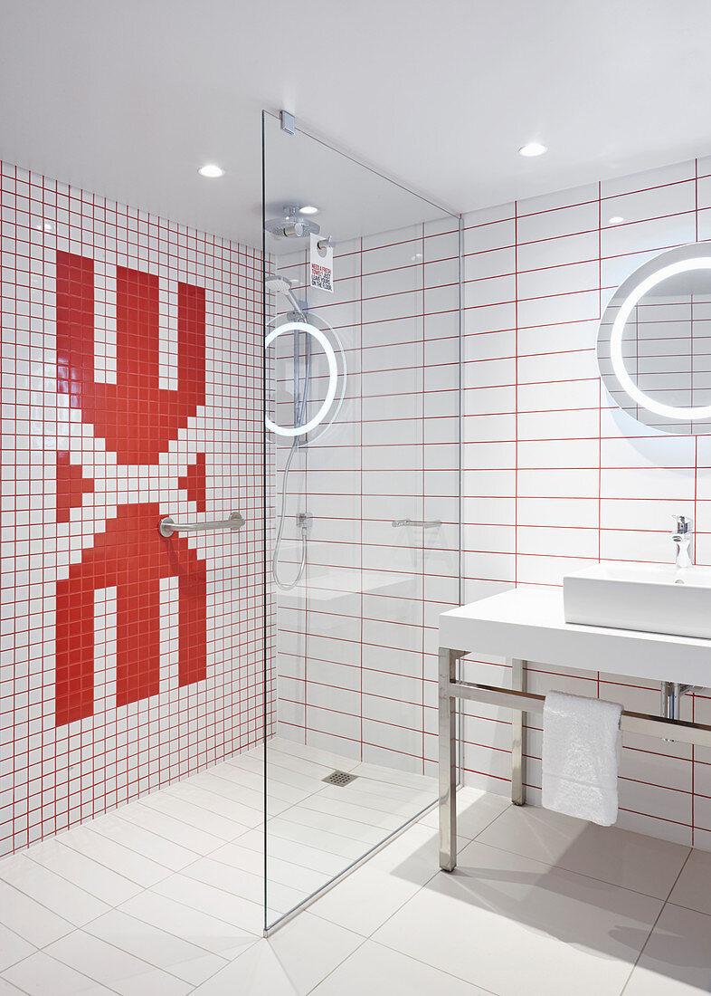 Red and white wall tiles and glass partition wall in designer bathroom
