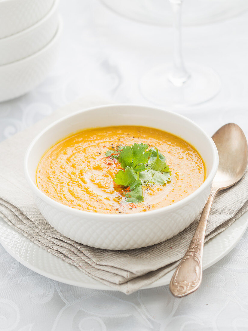 Creamy pumpkin soup on a clear background.