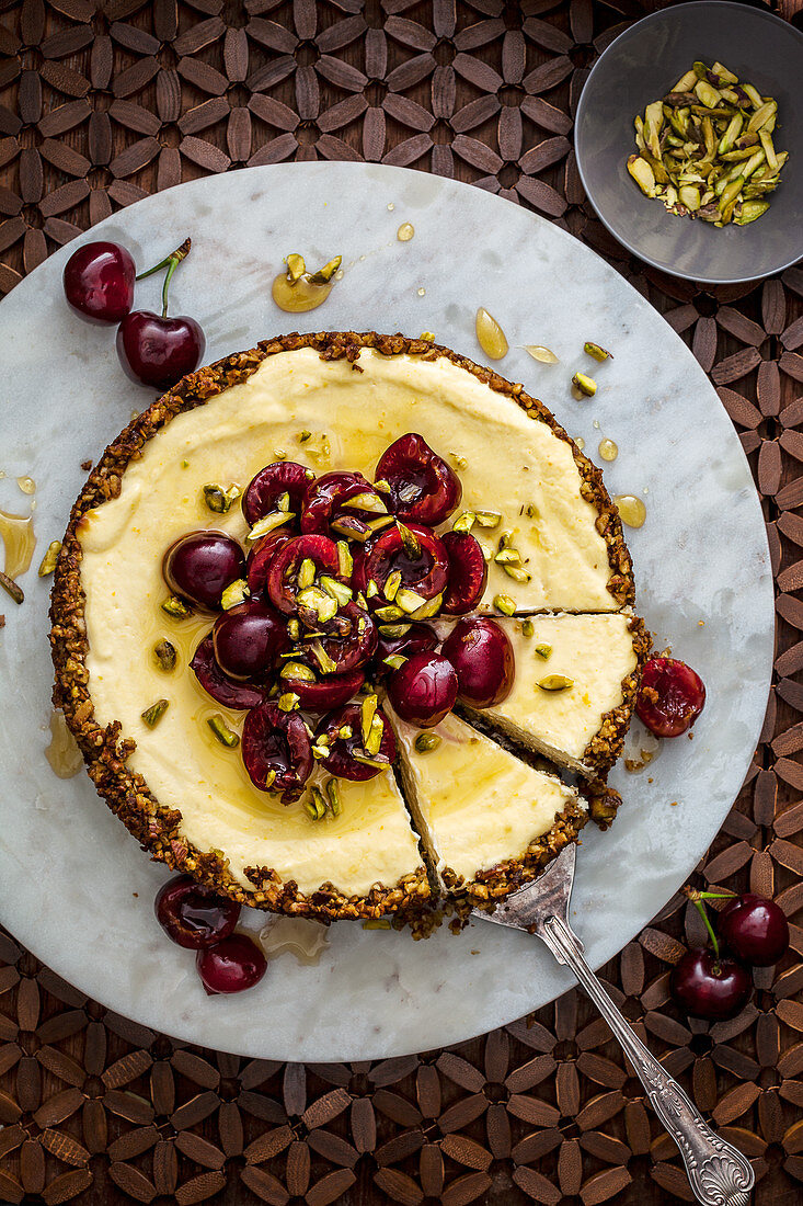 Pistachio and labne cheesecake with cherries and pistachios