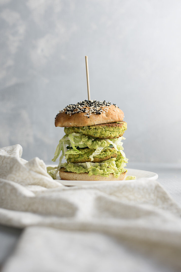 A burger with zucchini patties, cabbage and avocado cream