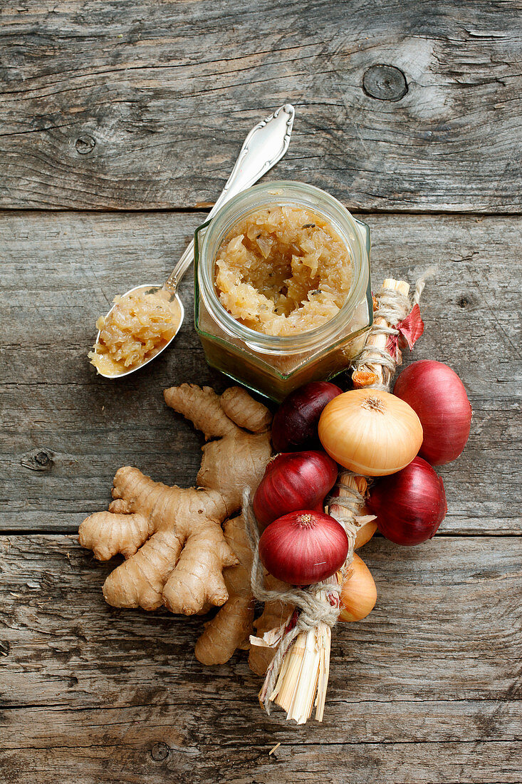 Ginger and onion jam with ingredients on a wooden surface