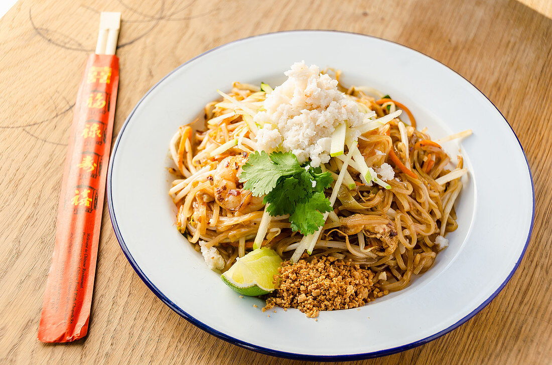 Pad thai stir fried noodles with prawns, chilli, beans, sprouts, spring onions, carrots, crab meat, shredded apple, lime and peanut