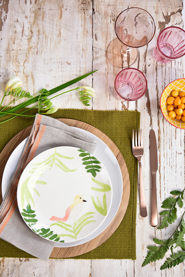 An Icelandic-style place setting with a wooden platter and a bird pattern