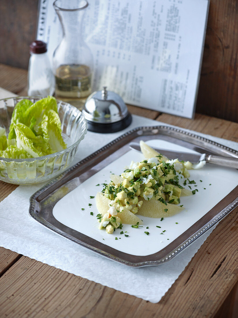 Avocado-Tatar mit geräuchertem Schellfisch auf silberner Servierplatte