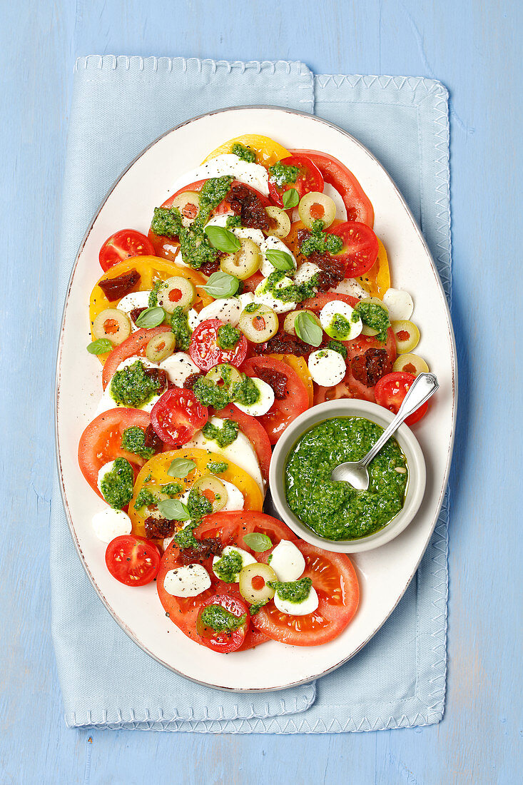 Caprese with olives and homemade rocket pesto