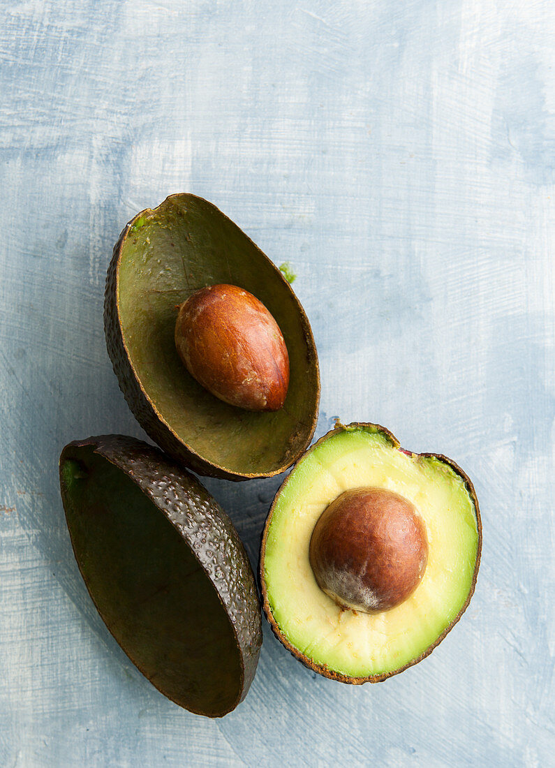 Avocadohälfte und leere Schalen mit Kern