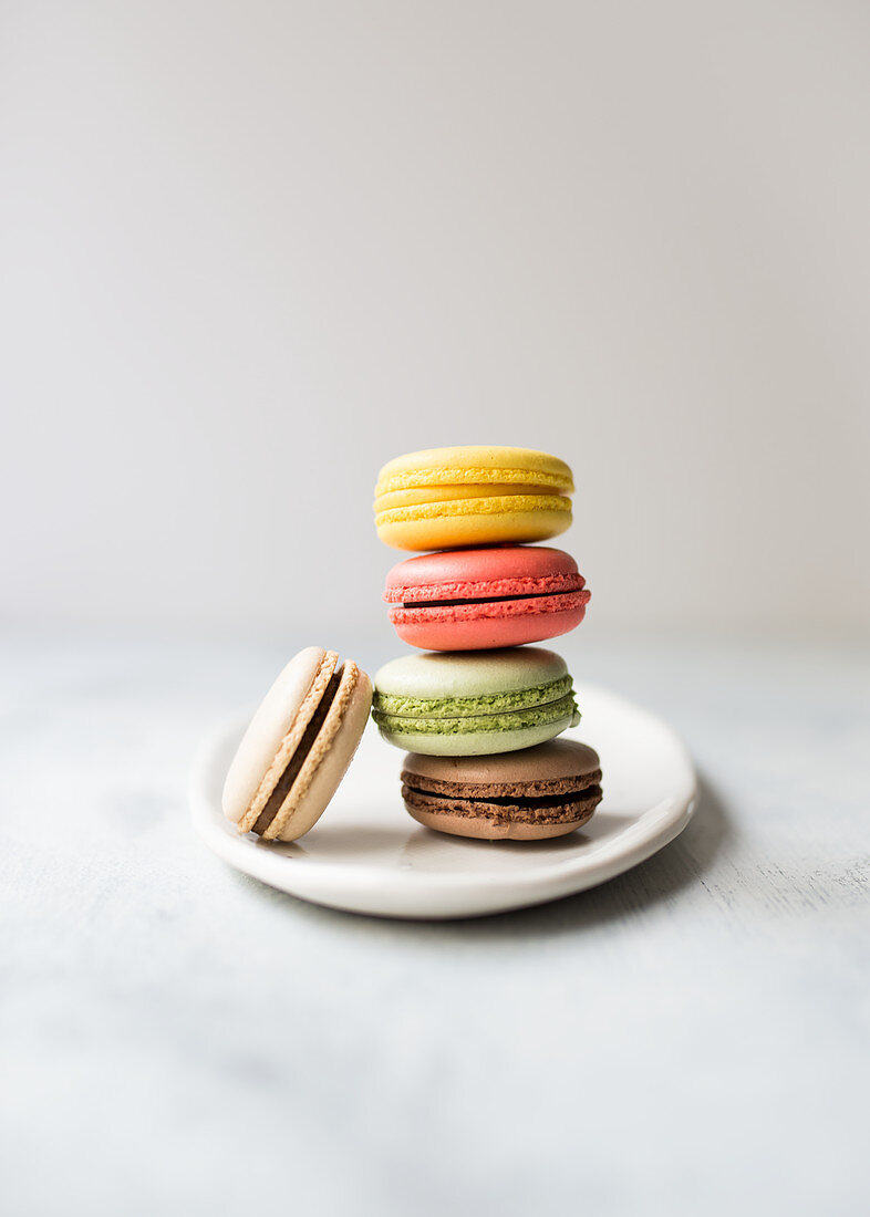 A stack of colourful macarons against a white background