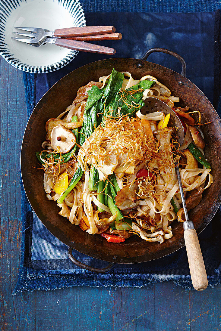 Noodle and vegetable stir fry in a wok